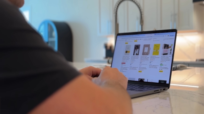 Person browsing book listings on a laptop while preparing to open a KDP account